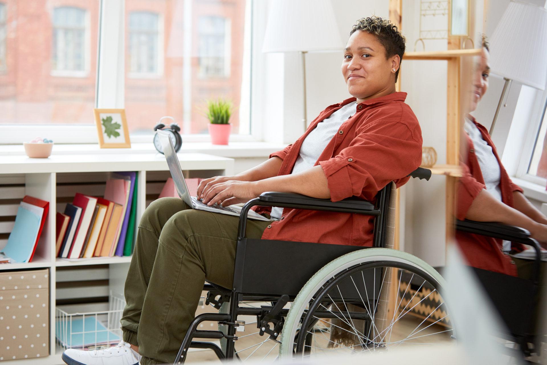 A woman in a wheelchair using her laptop